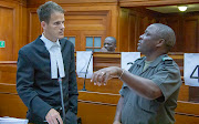 Sergeant Minye (right) explains how he tracked the alleged killer Blessing Bveni (centre) to the state prosecutor Chris Burke (left) in the Cape Town high court in March 2020.