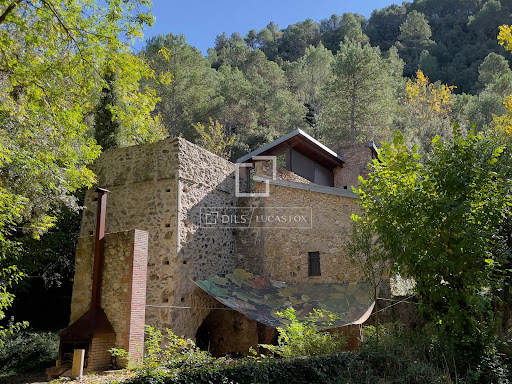 Stone building surrounded by trees in this luxury house for sale in Sant Llorenç de la Muga ($1,575,946 - 309 m²)