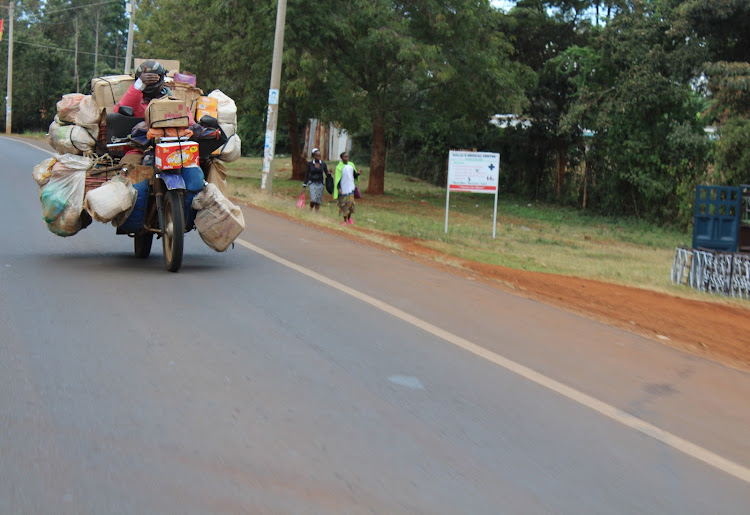 A boda boda rider transports assorted items to retail shops along the Nyeri-Karatina highway