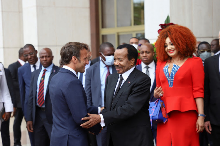 Cameroon's President Paul Biya shakes hands with French President Emmanuel Macron as Biya's wife Chantal looks on, in Yaounde, Cameroon, July 26 2022. Picture: REUTERS/Desire Danga Essigue