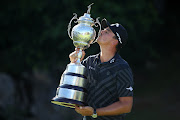 Christian Bezuidenhout of South Africa kisses the trophy after his victory.