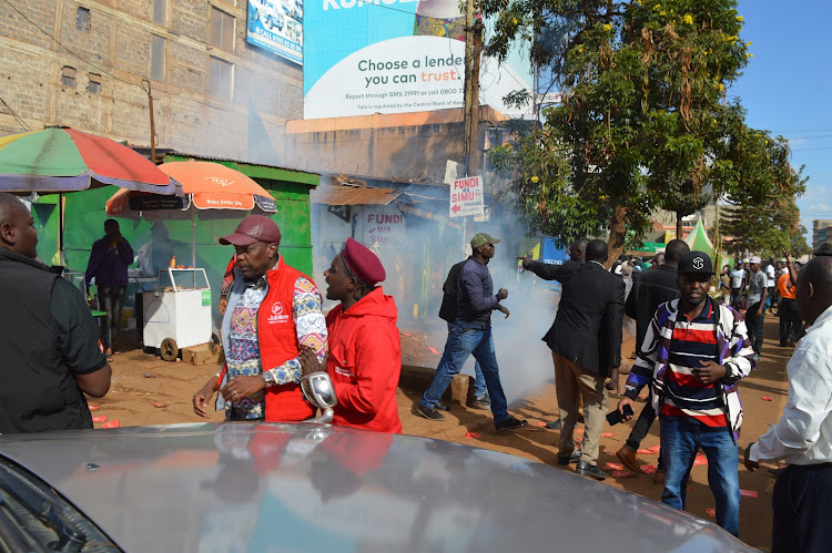 Jubilee secretary general Jeremiah Kioni is whisked to safety after a teargas canister was hurled at Azimio people's baraza meeting in Kiambu town on March 17, 2023.