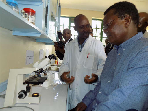 Kakamega Deputy Governor Prof. Philip Kutima being taken through the laboratory processes by Dr.David Ouna the Assistant Director of laboratory services during the launch of veterinary lab in Kakamega on Wednesday