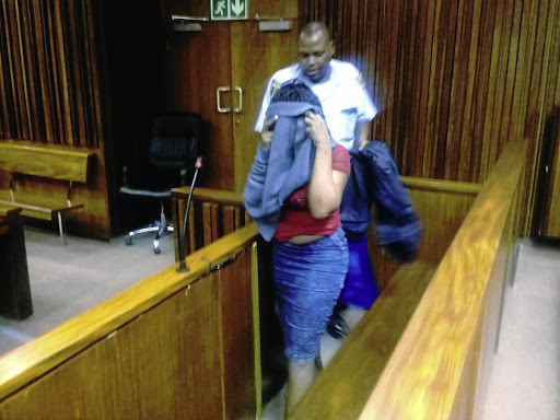 The 29-year-old woman found guilty of defeating the ends of justice over the rape of her child hides her face as she leaves the courtroom in the South Gauteng High Court in Johannesburg yesterday. / SUPPLIED