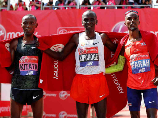 Kenya's Eliud Kipchoge celebrates with second placed Ethiopian Tola Shura and third placed Mo Farah of Britain after the men's elite race in the London Marathon, April 22, 2018. /REUTERS