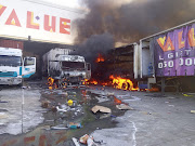 Trucks burn outside a warehouse in Cato Ridge, KwaZulu-Natal during the unrest in July 2021. File image