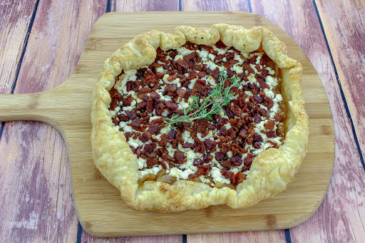 Caramelized onion and goat cheese tart with a sprig of thyme.