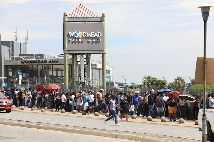 Customers stand in a long queue outside Woodmead Shopping Centre in hopes of finding a bargain this Black Friday.