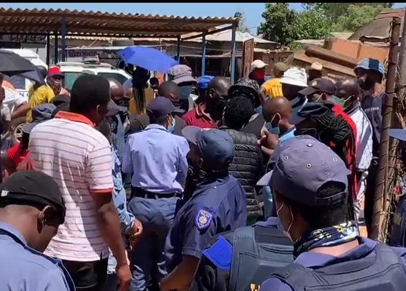 Tshwane metro police and SAPS form a perimeter around the voting station to protect IEC officials and voters, as scores of people, who claim they have not been allowed to register, try to get into the voting station.