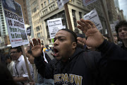 A man marches with his hands up as students and activists hold a protest march through the streets of Manhattan against the verdict announced in the shooting death of Michael Brown, in New York. REUTERS