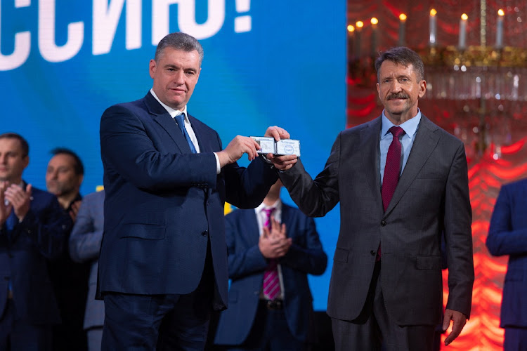 Viktor Bout, the Russian arms dealer freed from a 25 year sentence in the US receives a membership card from Leonid Slutsky, chai of the Liberal Democratic Party of Russia, in Moscow, Russia, December 12 2022. Picture: LIBERAL DEMOCRATIC PARTY OF RUSSIA/REUTERS