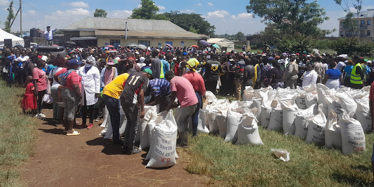 Juja residents queue to receive relief food in Theta on Saturday.