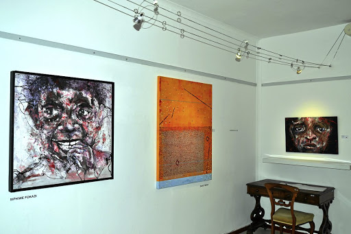 Siphiwe Fokazi work as displayed on the left, and David Tsoka's example of acrylic and oil on canvas art on the right (in orange).