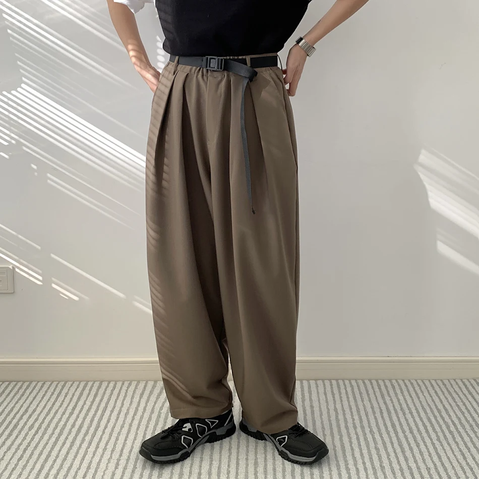 Muške ležerne pantalone tamnog stila, širokog kroja, sa efektom draperije. Udobne i elegantne, za svakodnevni moderan i opušten izgled.