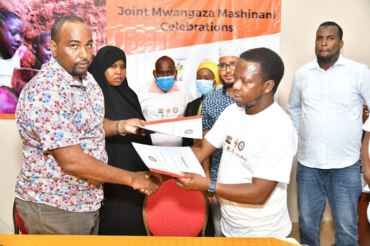 Garissa county secretary Abdi Ali (Left) with officials from Unicef