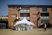 Community Members gather at a marquee set to host the memorial service for toddler, Caleb Ouman, in Belavista South of Johannesburg. 