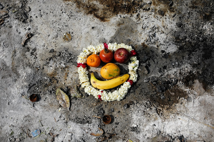 Flower garlands and fruits are placed on the spot where a person who died from the coronavirus disease (COVID-19) was cremated, as part of a ritual at a crematorium in New Delhi, India, April 30 2021.