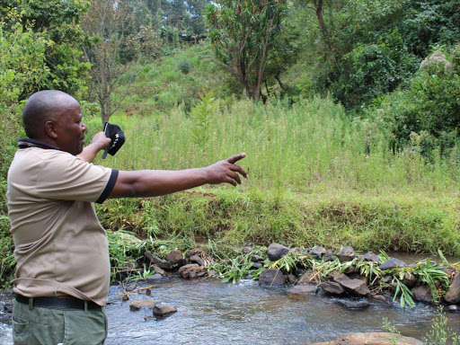 Wambugu Nyamu points at a neglected fish pond across River Thuti which belonged to a youth group which released the fish into the river