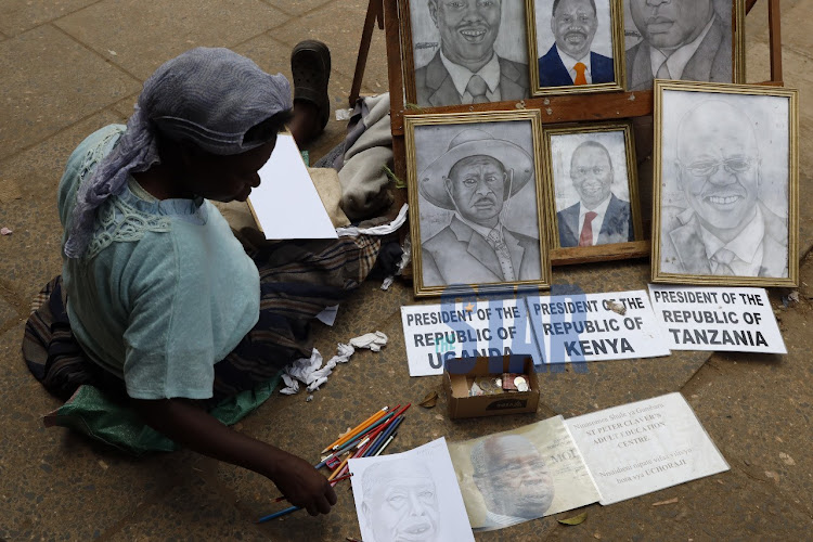 Cecilia Nabuya a 52 year old woman drawing portraits of the late retired president Moi along Tom Mboya street. /VICTOR IMBOTO