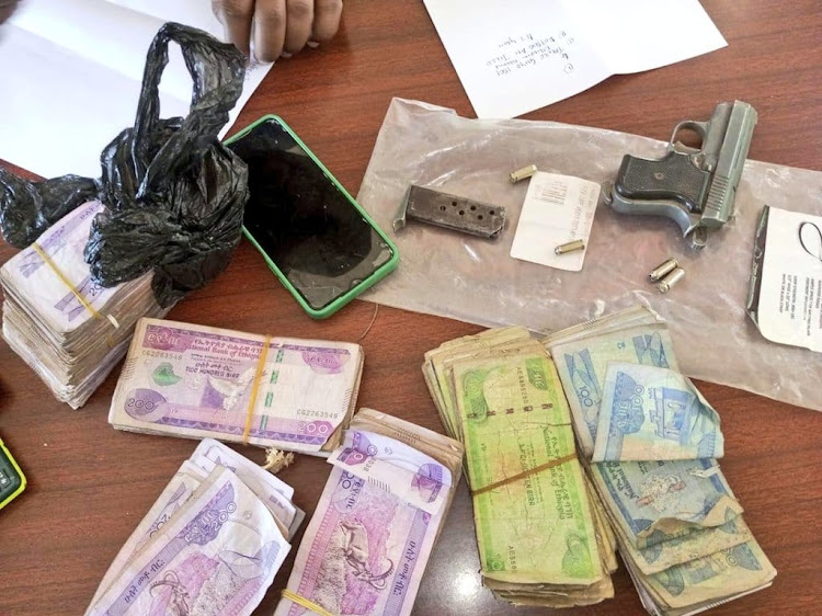 The pistol and cash recovered from the suspects in Moyale on February 18, 2024- Handout