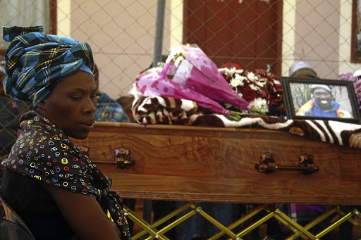 Jabulile Mgiqwa next to the coffin of her brother, Vusi Mgiqwa, who was allegedly punched by a white motorist and landed on his head in Selcourt, Springs, on October 26.