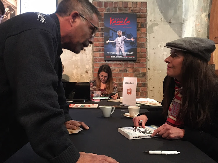 Journalist Chris Steyn signs a copy of Lost Boys of Bird Island at the OpenBook festival in Cape Town.