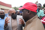 Home Affairs minister Aaron Motsoaledi gives reasons to this unidentified man why he should not be part of a meeting between government and community members of Diepsloot.