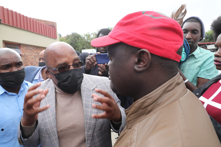 Home Affairs minister Aaron Motsoaledi gives reasons to this unidentified man why he should not be part of a meeting between government and community members of Diepsloot.