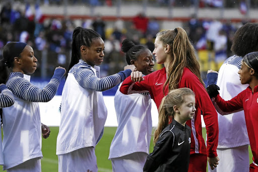 France and Canada players elbow-shake instead of shaking hands in Calais, France, due to the coronavirus epidemic.