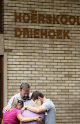 Parents at Hoërskool Driehoek in Vanderbijlpark pray after three pupils died when a walkway connecting two buildings at school collapsed on January 1 2019.