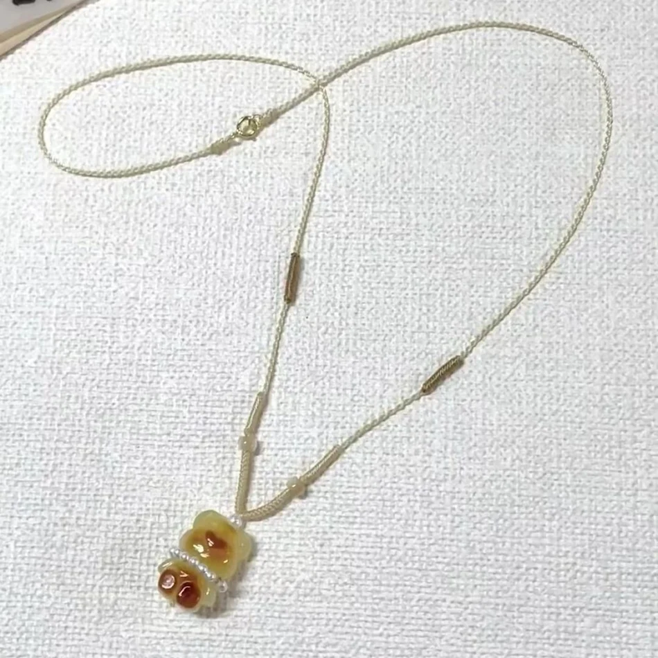 Collier tissé pour femme avec pendentif ours pudding caramel, un bijou adorable et unique pour accessoiriser votre style avec douceur.