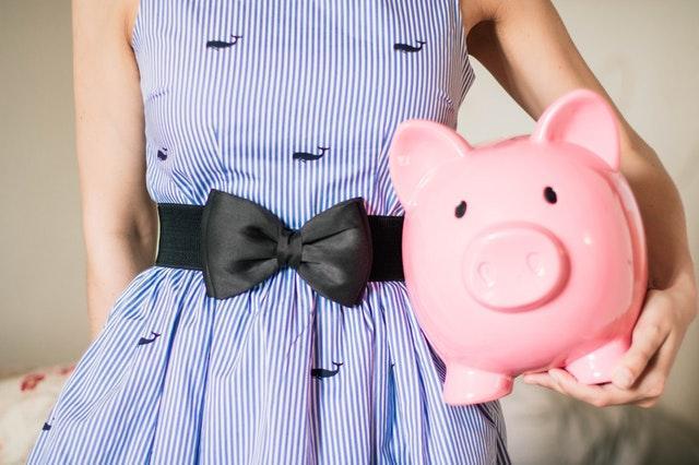 A girl holding a piggy bank.