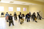 People wearing protective masks sit ahead of a vaccination, as South Africa rolls out the coronavirus disease vaccines to the elderly at the Munsieville Care for the Aged Centre outside Johannesburg, South Africa on May 17 2021. 
