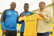 Defender Siyabonga Zulu (C) during his unveiling as a Mamelodi Sundowns new player on January 17 2018 at the club's headquarters in Chloorkop. Flanking him is the club president and billionaire owner Patrice Motsepe (R) and head coach Pitso Mosimane.    