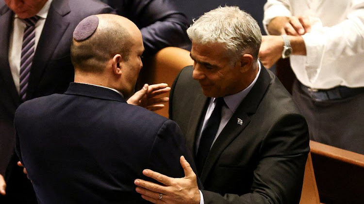 Naftali Bennett (L) and Yair Lapid (R) embraced each other after the Knesset dissolution vote.