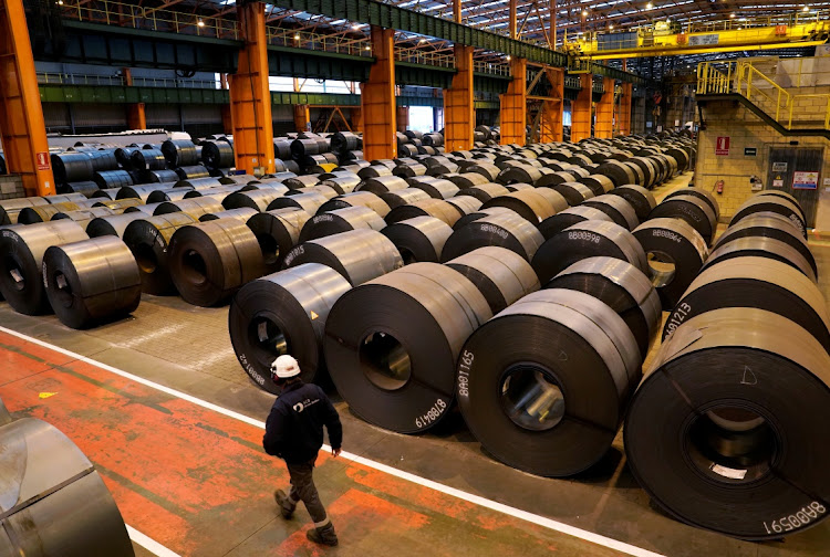 A worker walks by steel rolls at the ArcelorMittal steel plant in Sestao, Spain, on November 12 2018. Picture: REUTERS/VINCENT WEST