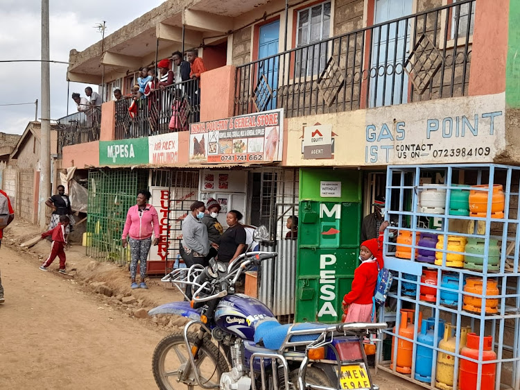 Residents mill at the scene where businessman Dickson Githenji was shot dead by gangsters at Mihang'o shopping centre in Kayole, Nairobi on Tuesday, June 29.