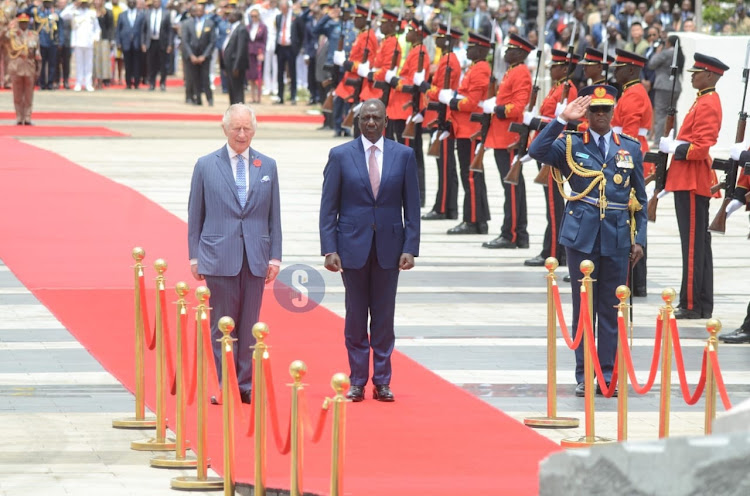 King Charles III and President William Ruto stand still as the national anthem is played moments after they arrived at the Uhuru gardens in Nairobi on October 31, 2023.