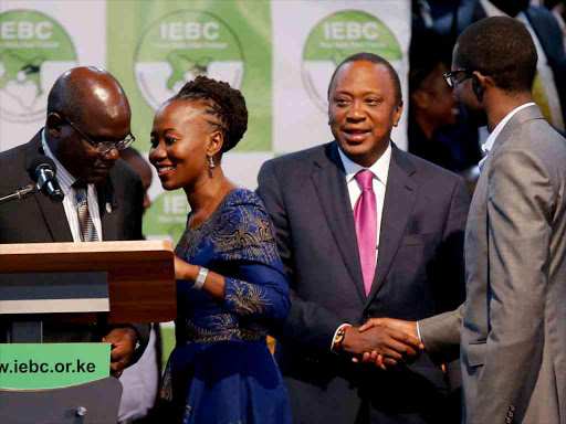 IEBC commissioner Roselyn Akombe talks to chairman Wafula Chebukati as President Uhuru Kenyatta talks to Chief Electoral Officer of IEBC Ezra Chiloba at Bomas of Kenya in Nairobi, August 11, 2017. /REUTERS