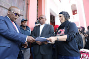 One of the leaders of the #TotalShutdown movement handing over a memorandum to Buffalo City mayor Xola Pakati at city hall. 