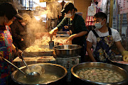 People wear protective masks to prevent the spread of the coronavirus disease (Covid-19) while selling meatballs in a market in Taipei, Taiwan, December 23, 2020. 