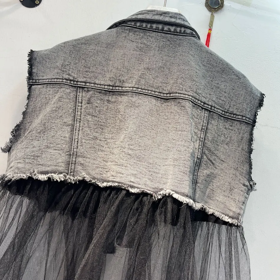 Colete jeans com pedras de strass de gemas coloridas, rede e costura pesada. Adicione um toque glamouroso ao seu visual com esta peça única.