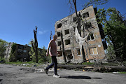 A resident walks past an apartment building heavily damaged by a Russian military strike in the town of Avdiivka, amid Russia's attack on Ukraine, near a frontline in Donetsk region, Ukraine May 5, 2023. 