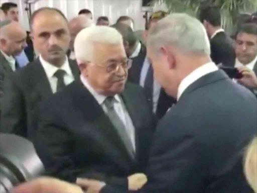 A still image taken from a video shows Palestinian President Mahmoud Abbas shaking hands with Israel's Prime Minister Benjamin Netanyahu at the funeral of former Israeli President Shimon Peres in Jerusalem September 30, 2016. /REUTERS