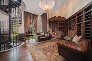 The library in the Sandhurst house, with a spiral staircase that leads down to a wine cellar.