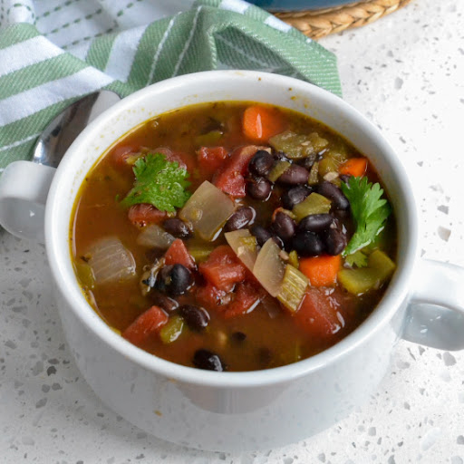 A quick and easy flavor packed Black Bean Soup with onions, carrot, celery, garlic, tomatoes, green chiles, and black beans all in a vegetable broth seasoned with cumin, marjoram and cilantro.