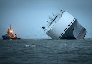 Salvage tugs tow the stricken vessel 'Hoegh Osaka' to a anchor point in the the Solent on January 7, 2015 in Cowes, England.