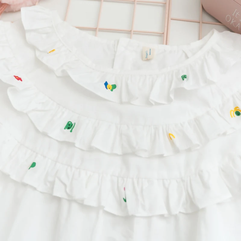 Chemise de poupée blanche en coton ample, manches mi-longues, idéale. Confortable, polyvalente, pour habiller votre poupée avec style et un look adorable.