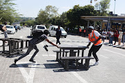 A protesting student blocks a road with benches at the University of the Witwatersrand in Johannesburg on March 2 2023.