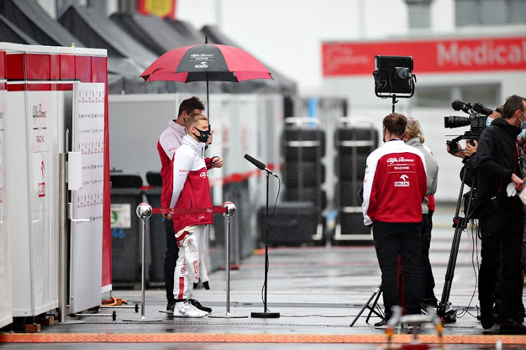 Mick Schumacher of Germany and Alfa Romeo Racing talks to the media in the Paddock after missing his chance to drive in FP1 due to a weather delay during practice ahead of the F1 Eifel Grand Prix at Nuerburgring on October 09, 2020 in Nuerburg, Germany.